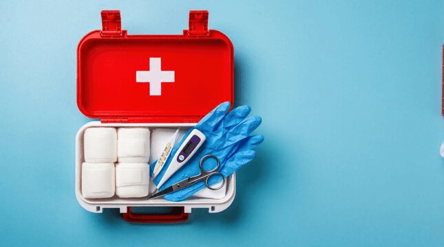 Open first aid kit with gloves, thermometer and dressings